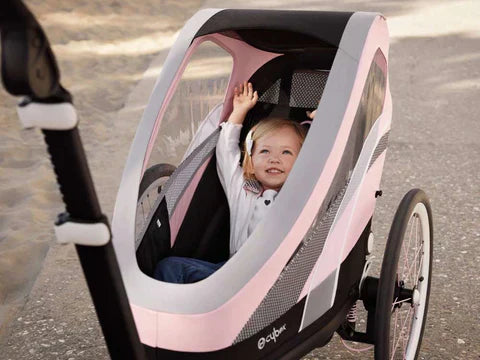 Cybex Zeno multisport running stroller with child inside, featuring hands-free running and cycling kits.