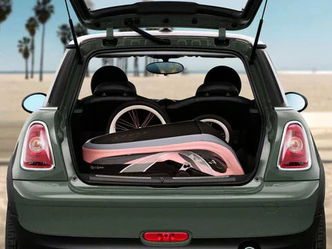 Cybex Zeno stroller compactly stored in a car trunk near a beach.